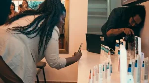 Influencer fotografando produtos de uma empresa parceira em evento corporativo.